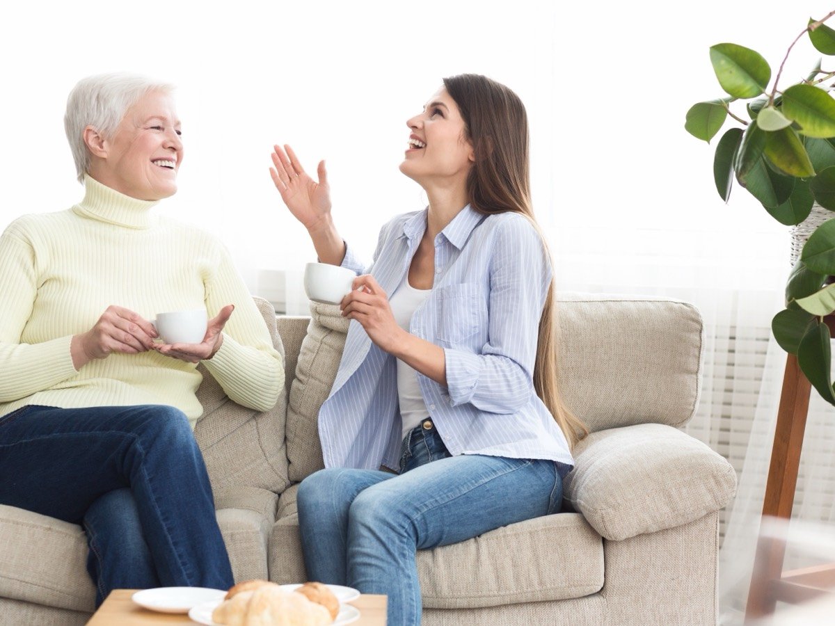 Mãe e filha conversando no sofá da sala